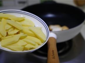 然后再将土豆去皮改刀下锅煎至出味。