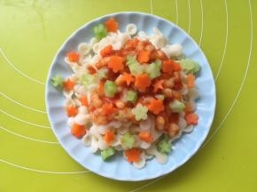 淋上番茄虾滑，再撒上胡萝卜跟乳瓜花朵装饰，宝贝的虾滑蝴蝶面就做好的