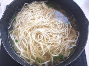 捞出面条，加入到花蛤汤中，小火煮开