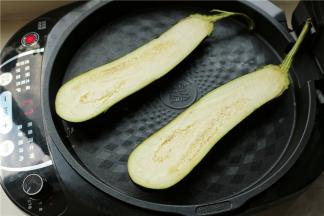茄子洗净，不需要去把。纵剖成两半，皮朝下放入苏泊尔电饼铛里面。