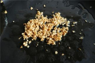 锅里放入少许油，下入一半蒜末炒成金黄色。