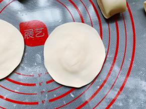 从冰箱取出冷冻过的白萝卜丝肉馅，开始包馅，取一个小剂子用手按扁，然后用擀面杖擀成中间厚四边薄的圆片。