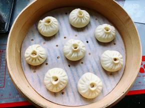 依次包好所有的包子，整齐地并隔开一定的距离摆放在蒸笼里，盖上锅盖，室温醒发20-30分钟，千万不要发过了哦。