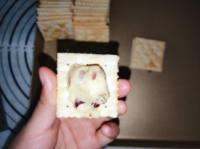 取一块饼干，抹上一勺牛扎馅，盖上另外一片