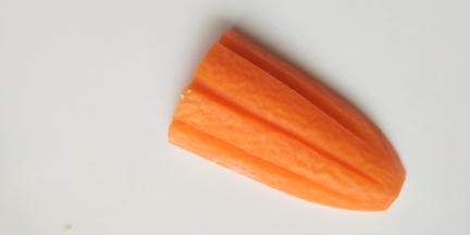 我们再来个升级版的萝卜花，胡萝卜切下来以后，竖着用刀切三个凹槽