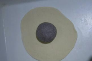 黑色面团揉圆，白色面团擀成薄饼(大小能包过黑色面团即可)