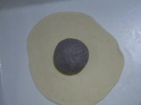 黑色面团揉圆，白色面团擀成薄饼(大小能包过黑色面团即可)