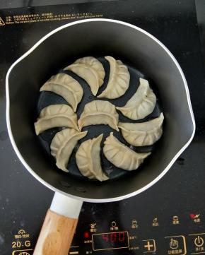 拿出九阳不粘小奶锅，放少许食用油。然后码放好饺子，转小火。
