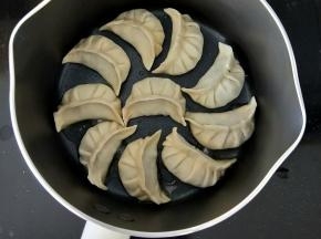 拿出九阳不粘小奶锅，放少许食用油。然后码放好饺子，转小火。