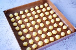 把冷藏好的面团分成10克为一份，揉圆放入烤盘中