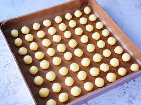 把冷藏好的面团分成10克为一份，揉圆放入烤盘中
