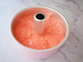 把拌匀的蛋糕糊倒入学厨8寸的中空模具中，端起模具的两端，指拇按住中空柱上空，轻轻震几下，震出大气泡