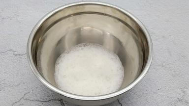 将蛋白里加入3滴白醋去腥，用电动打蛋器快速打发到鱼眼泡状态时，加入三分之一的糖粉。