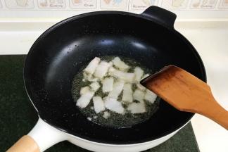 开火，往九阳轻奢炒锅中倒入适量食用油，油烧至三成热时，加入五花肉，直至五花肉爆出油，肉色变白。