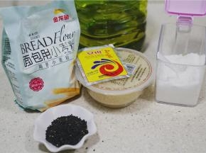 备好如图所用食材，金龙鱼面包用小麦粉，酒酿，玉米油，白糖，熟芝麻，酵母及少许细盐。