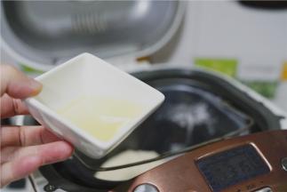 然后再加入玉米油，加入油之后盖一下保鲜膜，揉至油面完全融合之后就可以拿掉保鲜膜。