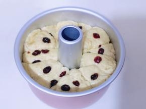 发酵好的面包胚明显炒大了很多!刷上一层炼乳黄油酱,再撒几颗蔓越莓!