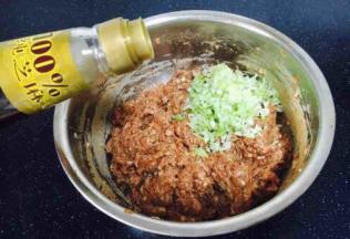 最后放入葱花，在葱花上放约20g左右的香油，先用香油把葱花拌匀，再将葱花与肉馅充分调匀，即朝一个方向搅拌均匀，大约搅拌100下左右。 先用油裹住葱花的目的是防止葱汁外溢，造成肉馅葱味过重。猪肉馅调好了备用。