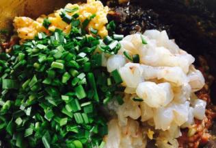 往调好的猪肉馅里放入虾仁、鸡蛋、木耳、韭菜。 
把切好的韭菜放入调好的肉馅中，先往韭菜倒入少许的香油，把韭菜搅和一下，然后再把所有食材和肉馅调匀，还是朝同一个方向搅拌。 
先把韭菜裹上一层香油，目的是锁住一是韭菜的水分，二是避免韭菜出汤，影响包饺子的手感。