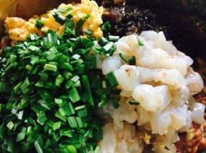 往调好的猪肉馅里放入虾仁、鸡蛋、木耳、韭菜。 
把切好的韭菜放入调好的肉馅中，先往韭菜倒入少许的香油，把韭菜搅和一下，然后再把所有食材和肉馅调匀，还是朝同一个方向搅拌。 
先把韭菜裹上一层香油，目的是锁住一是韭菜的水分，二是避免韭菜出汤，影响包饺子的手感。