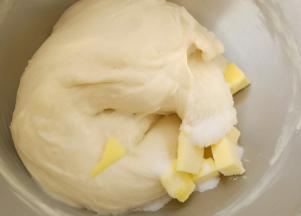 这时就可以放入盐和软化好的黄油了，继续揉。