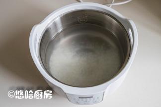 大米淘洗干净，提前浸泡30分钟，放入炖锅中，加入清水，米水的比例是1:12，喜欢喝浓稠一点粥的，水可以少放一点，小编用的炖锅还是这几天一直在用的桃花盏，挺方便的。