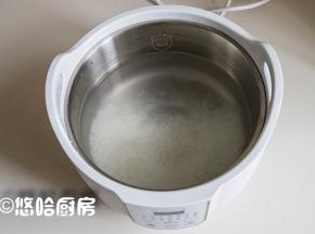 大米淘洗干净，提前浸泡30分钟，放入炖锅中，加入清水，米水的比例是1:12，喜欢喝浓稠一点粥的，水可以少放一点，小编用的炖锅还是这几天一直在用的桃花盏，挺方便的。