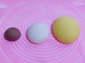 将发酵好的南瓜面团，白面团揉至光滑！盖上保鲜膜醒10分钟！