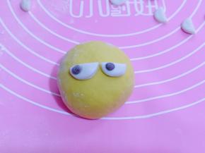 将两个半圆行黏贴上去做眼睛，再取一块可可面球，做黑眼珠！如图