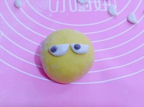 将两个半圆行黏贴上去做眼睛，再取一块可可面球，做黑眼珠！如图