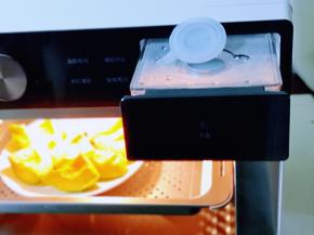 蒸烤箱水盒取出注满纯净水，再推回机体中！将切好的南瓜放入蒸盘中。100°蒸15分钟，结束后焖10分钟后取出！