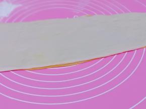 将南瓜面团用擀面杖擀薄，再把白面团擀薄，黄面皮放下面，白面团叠加上如图！