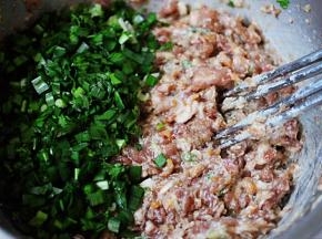 用筷子搅拌均匀所有的食材后，放入切碎的韭菜。