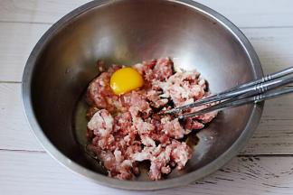 猪肉馅里加入生抽和料酒，然后打散一枚鸡蛋。