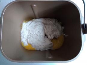 将发酵好的酵头和主面团里的蛋液、水、糖和盐倒入面包桶里