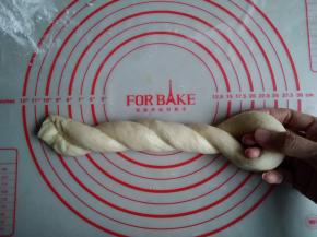 用右手固定对折的地方，左手将面团卷成麻花