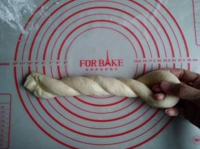 用右手固定对折的地方，左手将面团卷成麻花