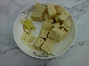 冻豆腐切成适当的块，姜切成条，蒜切成片