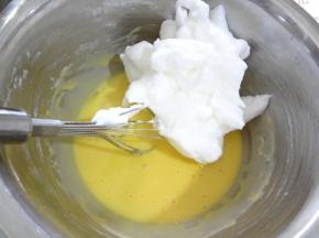 打好的蛋白分三次加入面糊中，第一次用刮刀分三分之一放入蛋黄糊中用手动蛋抽同样的手法混合