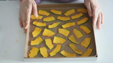 然后擦南瓜片的时候我们可以像这样，先把南瓜片大致摆在上面，就能知道大概需要的数量，然后摆满以后再多擦十来片的样子，可以弥补南瓜煮过以后体积的缩小，以及破裂的损耗