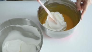 然后我们分三次混合蛋白霜与蛋黄糊，取1/3的蛋白霜到蛋黄糊中