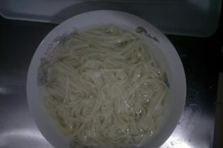 将煮熟的面条捞出，放入凉白开水中过一下