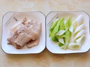 将煮好的五花肉切成薄片，葱切成斜段。