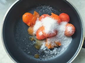 不粘锅内加入剥了皮的柿子果肉，加细砂糖