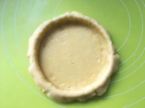 用手压一下模具底部，将挞皮铺均匀