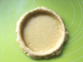 用手压一下模具底部，将挞皮铺均匀