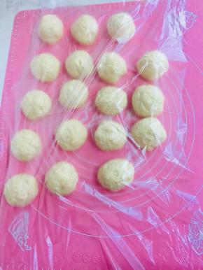 发酵好的面团充分排气后，分成50克一个的小挤子，揉圆。盖上保鲜膜醒10分钟。