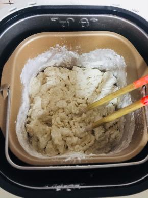 用筷子将材料搅拌均匀，蒙保鲜膜静置15分钟，让水分充分和面粉结合，这样随后揉面会很轻松的出膜哦！