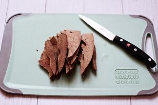 把煮熟的猪肝用刀切成薄片。