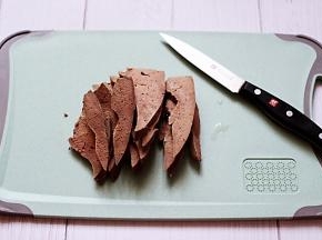 把煮熟的猪肝用刀切成薄片。